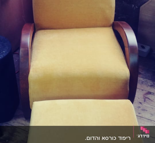 כורסה מרופדת בצבע צהוב עם הדום תואם